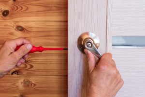 close-up-man-s-hand-installing-door-lock-home