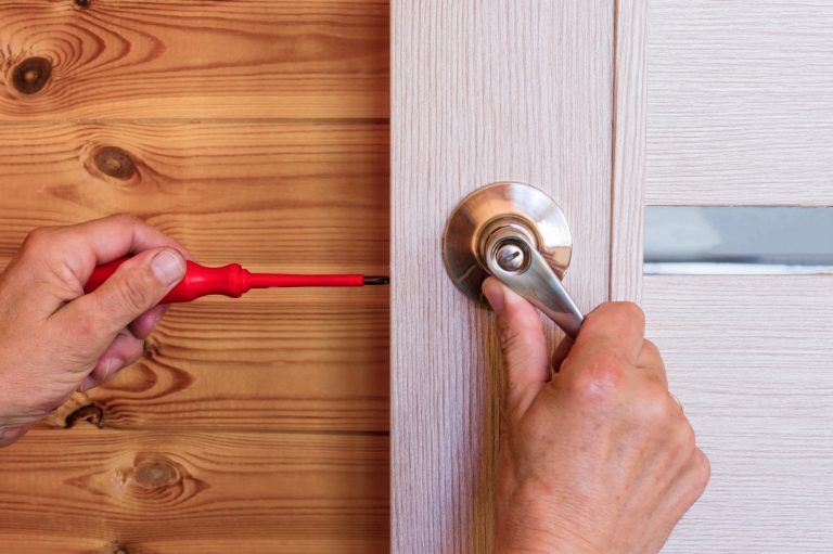 close-up-man-s-hand-installing-door-lock-home